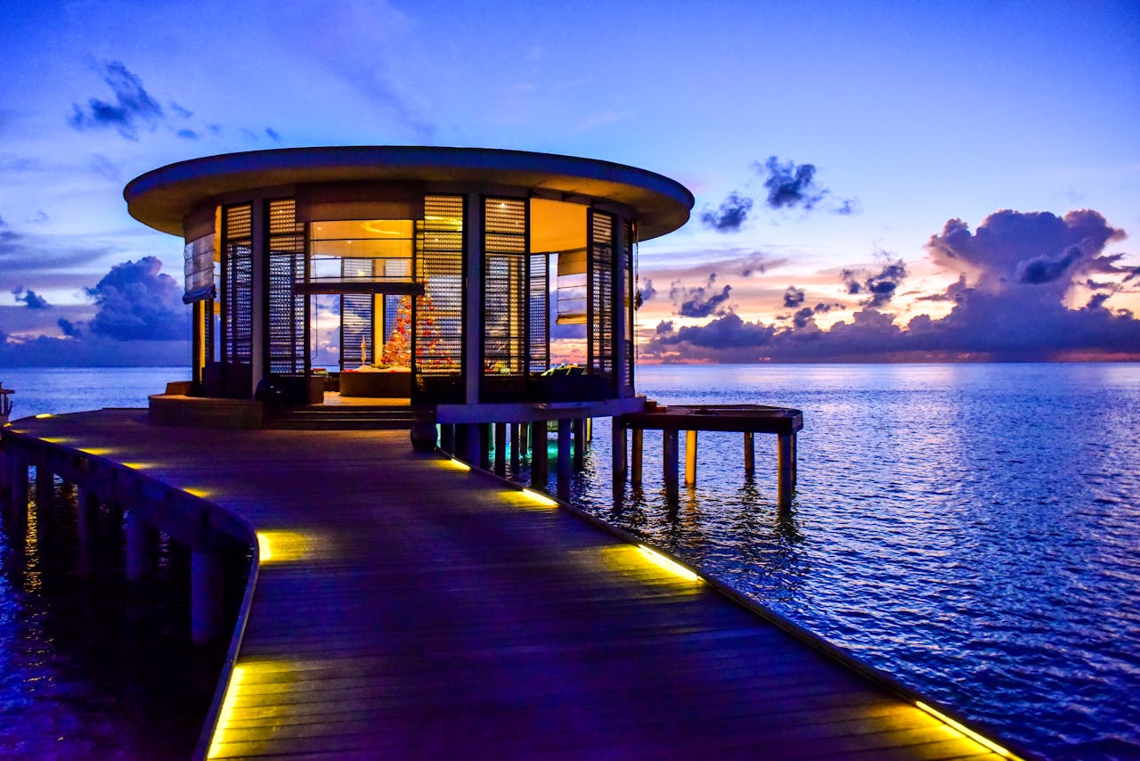 our-services-3 Beautiful round pavilion on a pier overlooking the tranquil sea at sunset.