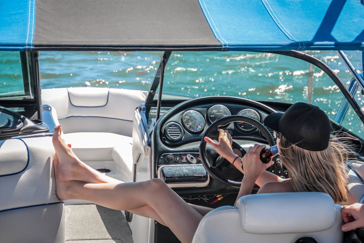 why-choose-us A woman enjoys a sunny day on a luxury boat, relaxing with a beverage.
