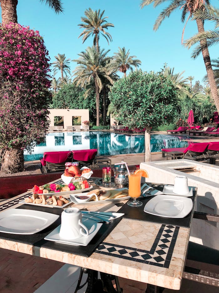 our-services-1 Enjoy a luxurious outdoor dining experience by the pool with lush greenery and delicious breakfast.
