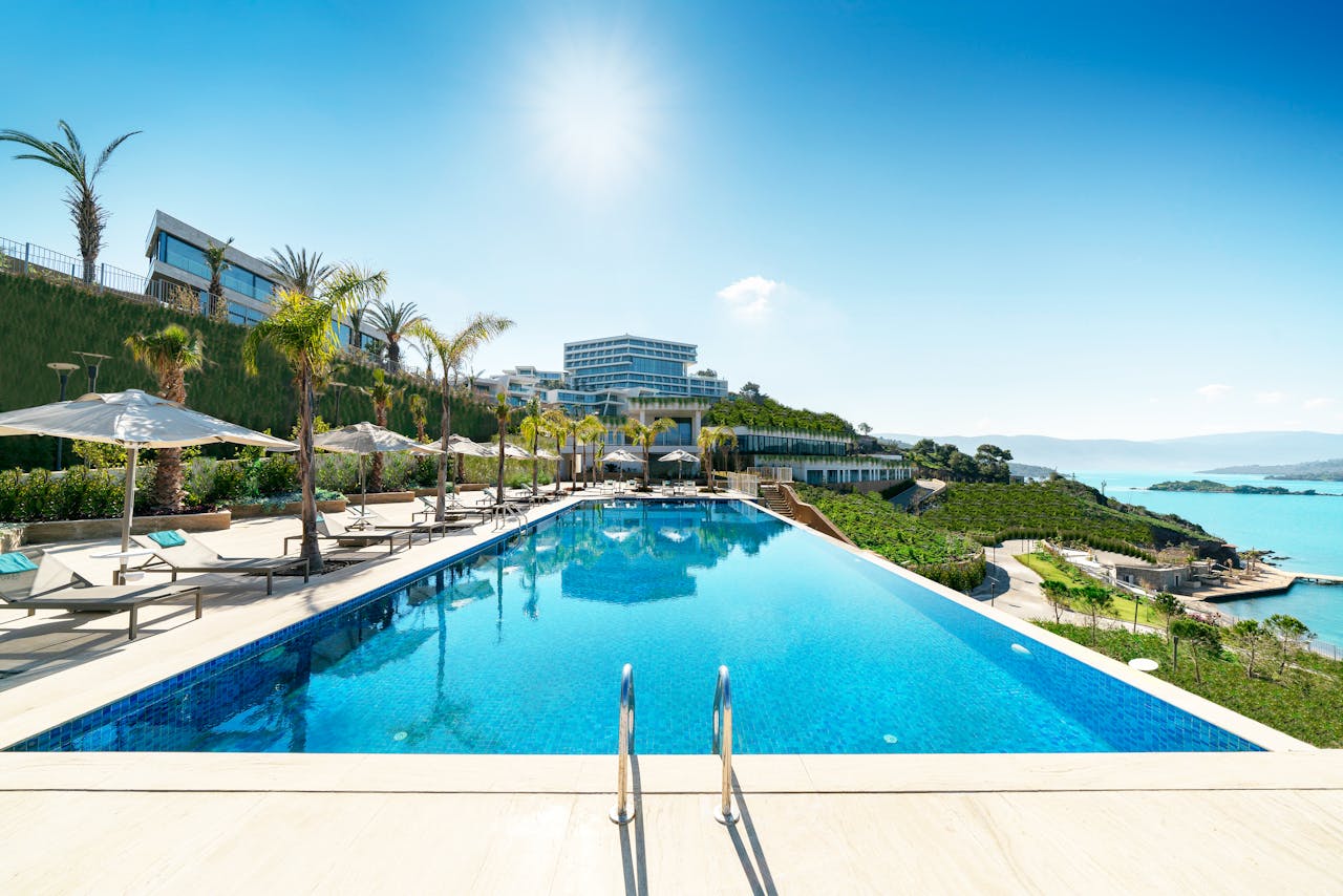 about-02 A luxurious seaside resort in Bodrum, Turkey, featuring a stunning infinity pool under sunny skies.