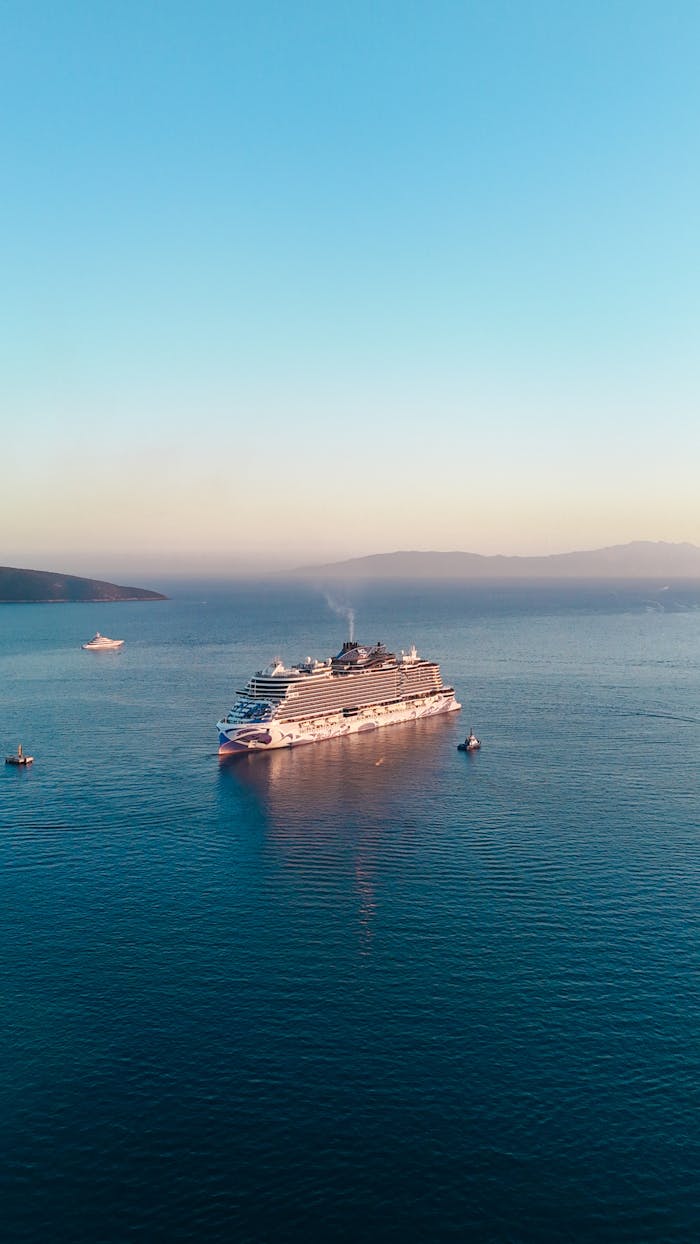 services-04 A luxury cruise ship sails serenely on open water during a vibrant sunset.
